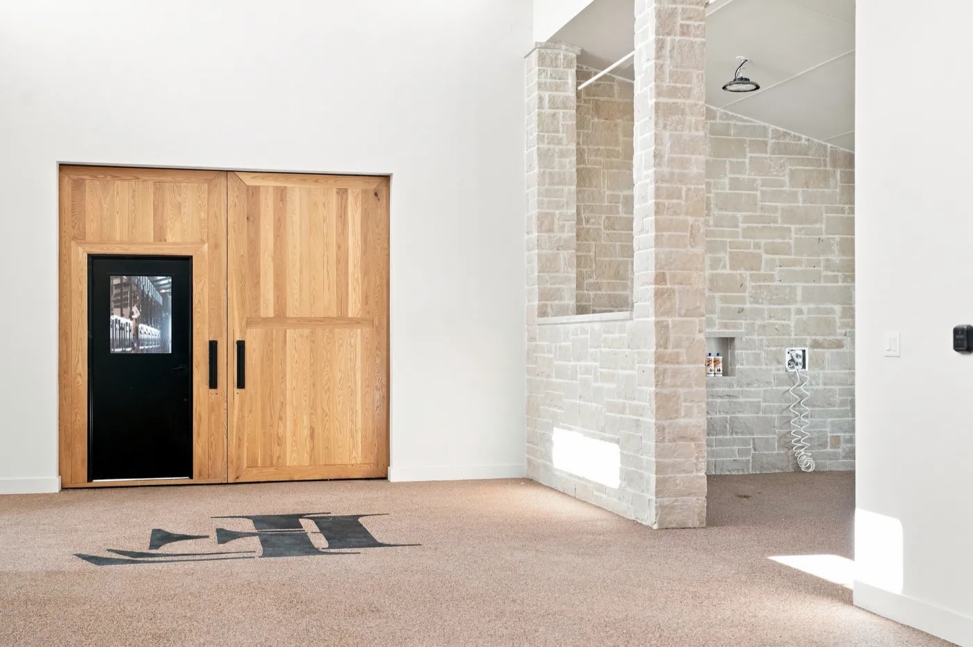 A stone wash rack inside the main barn at Franklin Farm, beside oak sliding doors.